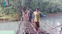 Aksi Kemanunggalan Babinsa: Sertu Abdul Aziz Dampingi Warga Seberangi Jembatan Gantung Buakkang